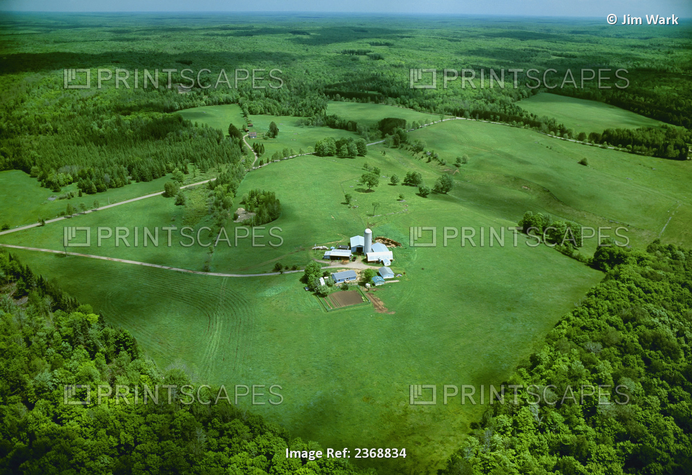 Agriculture - Aerial view of a farmstead in Spring surrounded by lush green ...