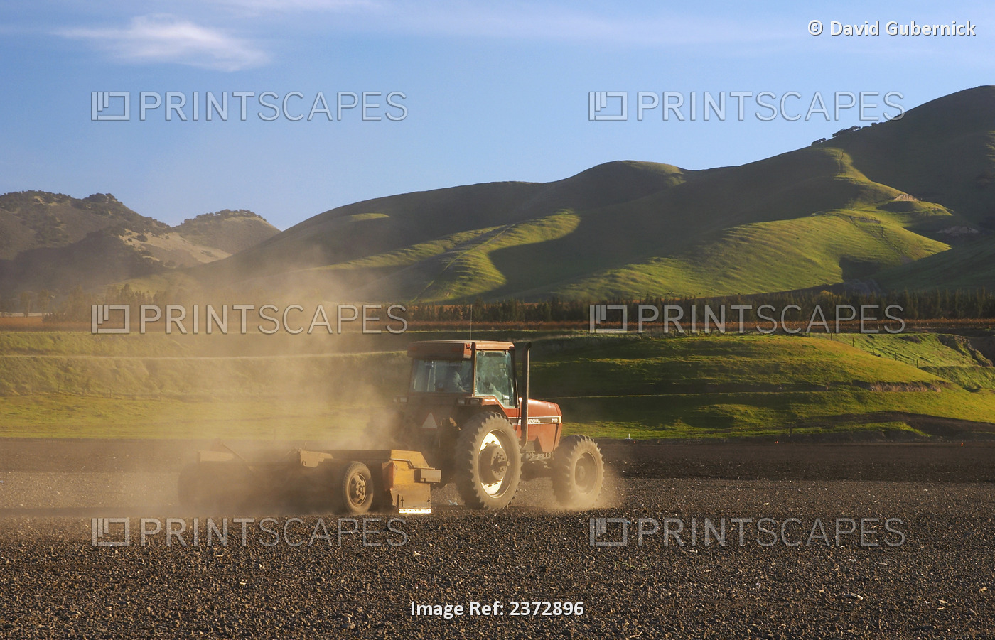 Agriculture - A tractor pulls a land leveler across a field in order to level ...