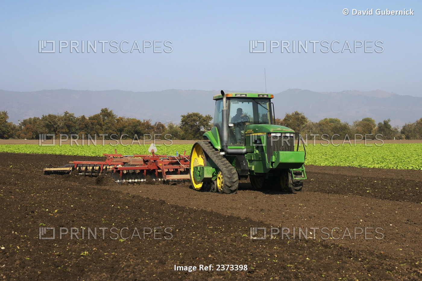 Agriculture - A John Deere tracked tractor and field implement disk a recently ...