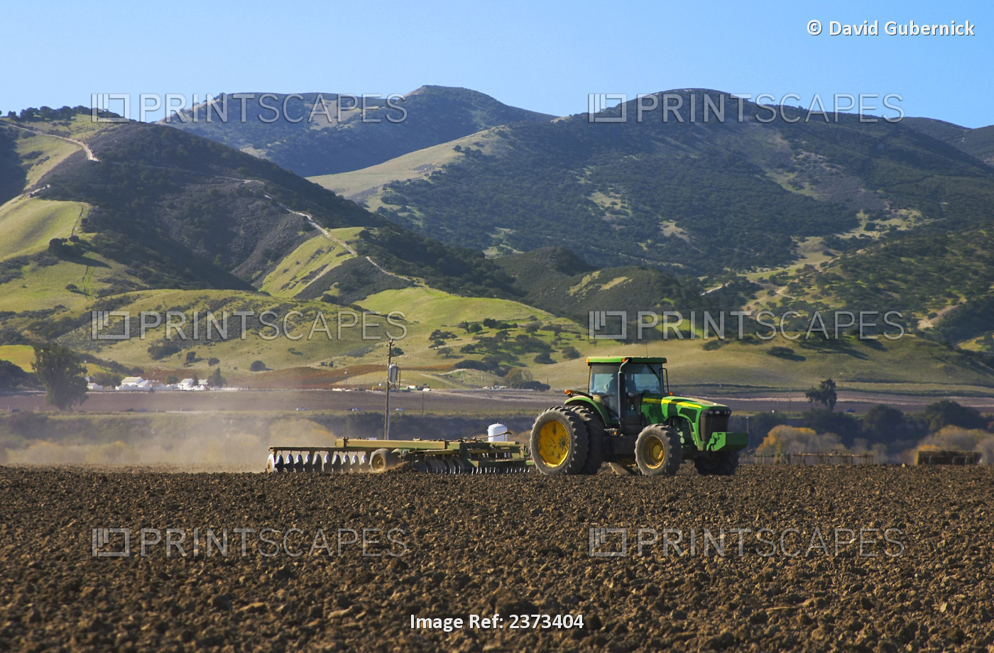 Agriculture - A John Deere tractor and field implement disk a recently ...