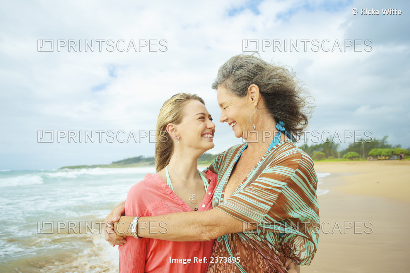 A Mother And Daughter Together On The Beach At The Water's Edge; Kauai, Hawaii, ...