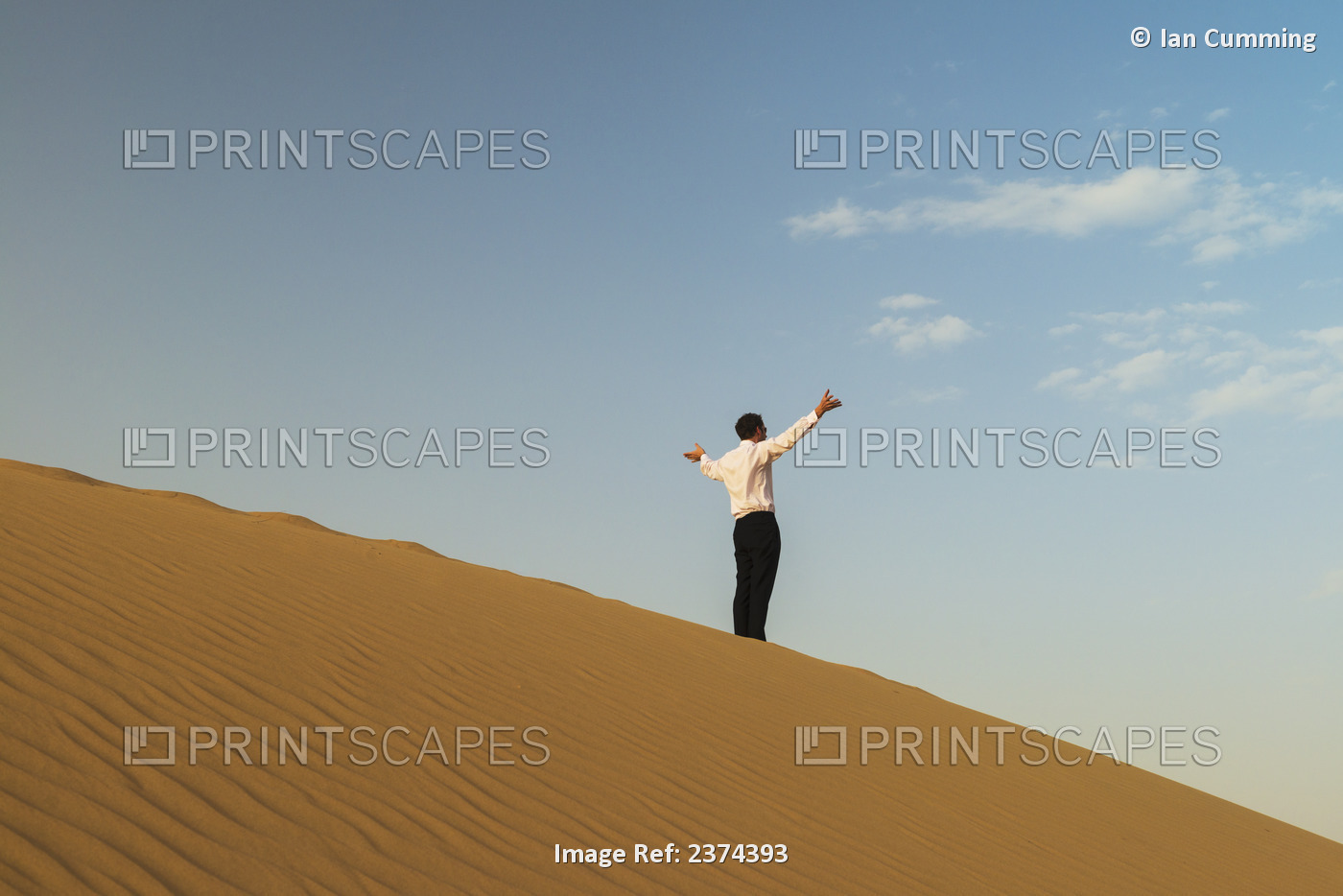 Man In Smart Clothes Waving For Attention On Top Of Sand Dune; Dubai, United ...