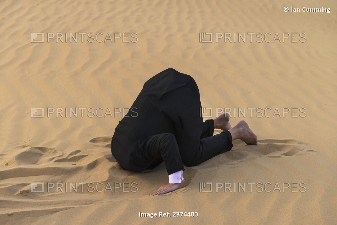 Man In Smart Suit With Head Buried In The Sand; Dubai, United Arab Emirates
