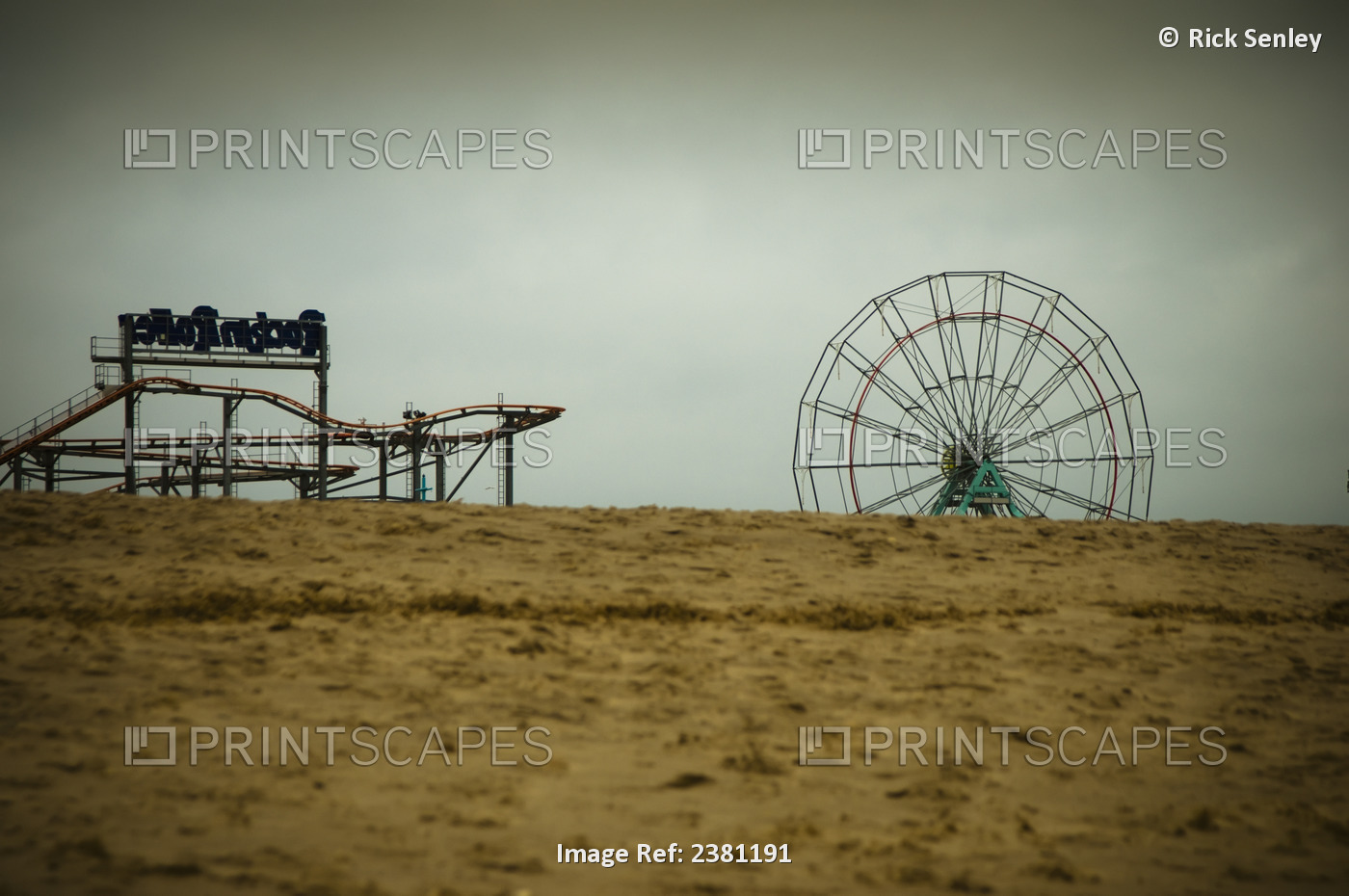 Winter On A Deserted Beach With A Closed Funfair In The Background; Skegness, ...