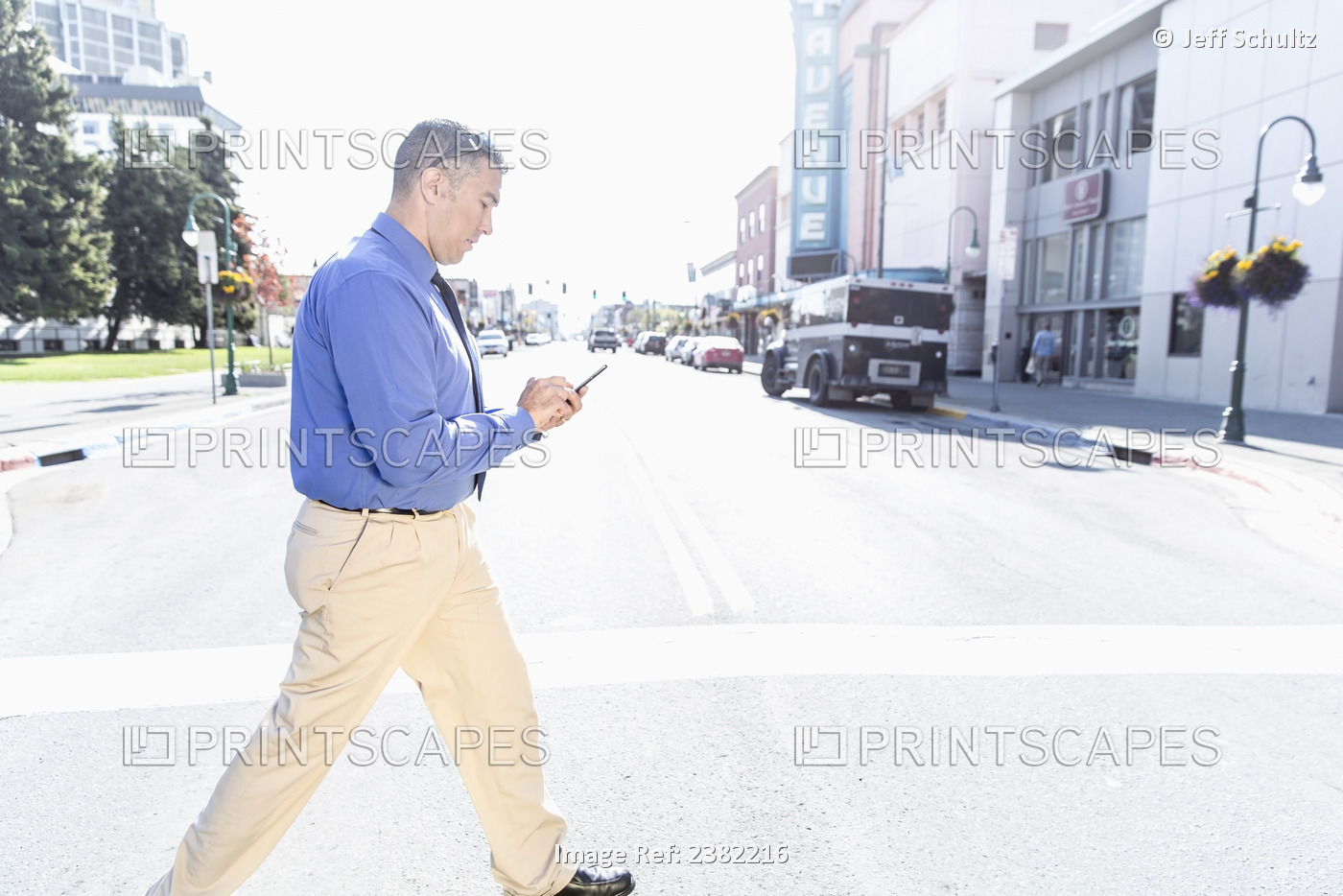 Alaska Native Inupiat Businessman Using Smart Phone In Downtown Street Scene, ...