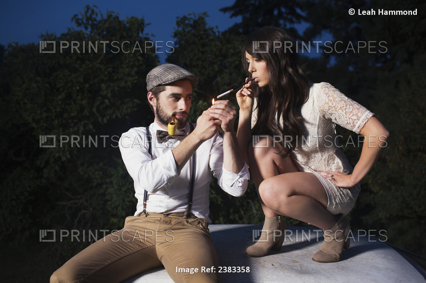 A Couple Sits On The Roof Of A Car Lighting A Cigarette; Edmonton, Alberta, ...