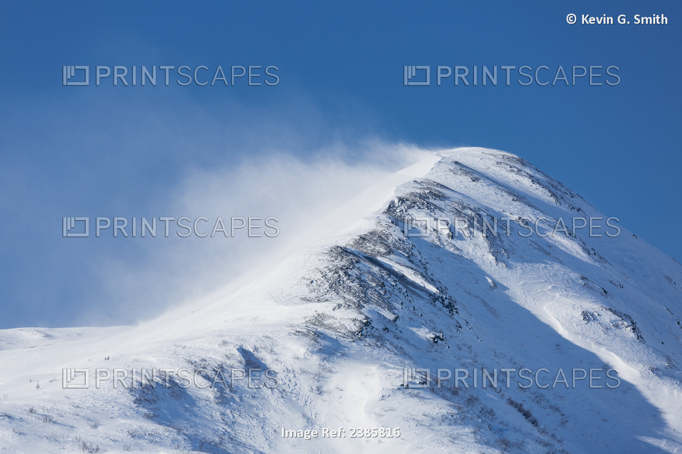 Wind Driven Snow Blows Off The Peak Of A Snow Covered Mountain In Wintertime, ...