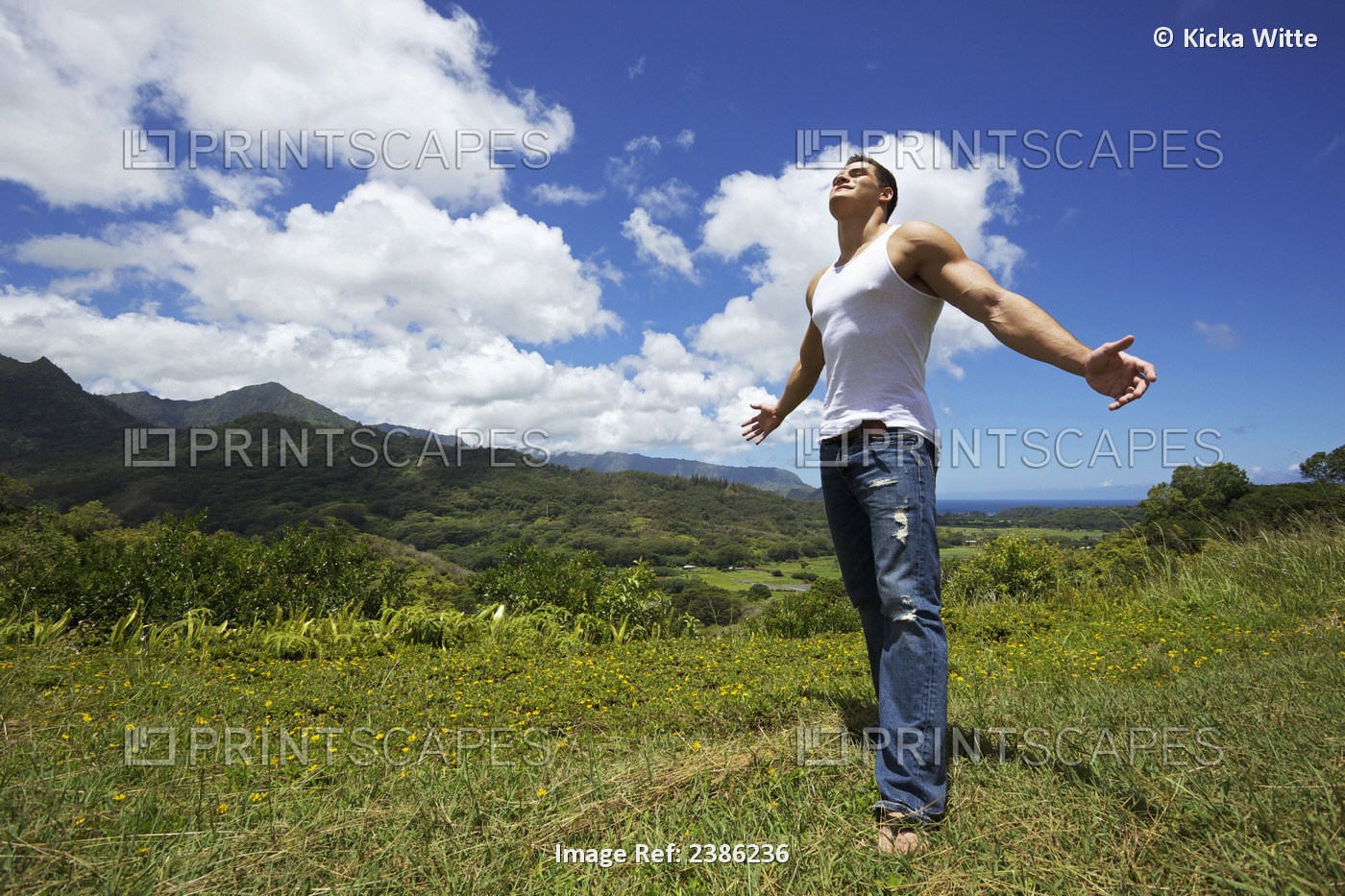 A Young Man Standing In A Grass Field With Arms Outstretched Looking Up At The ...