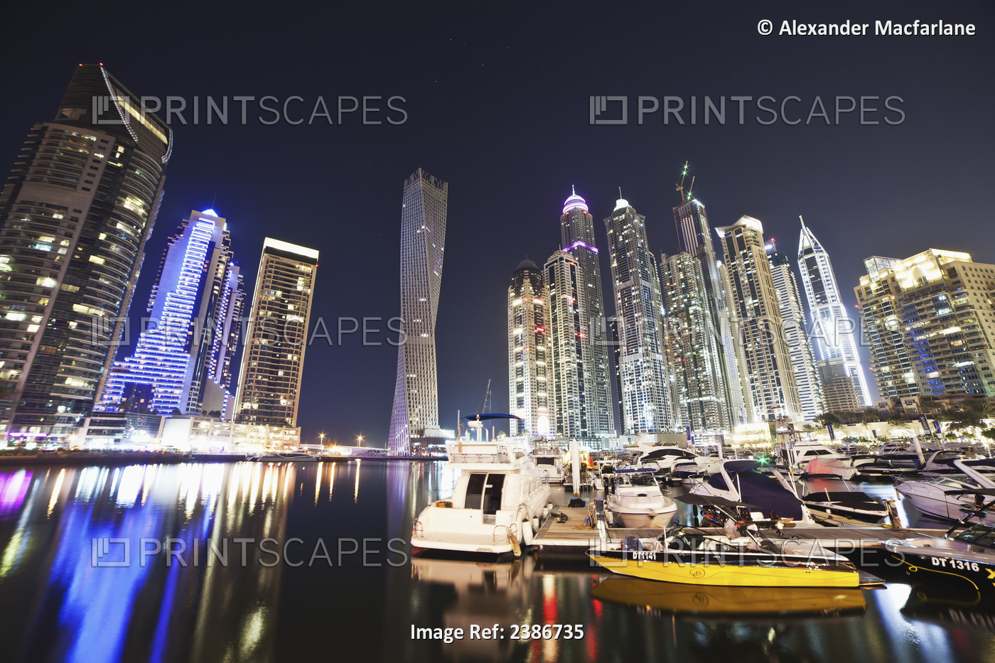 Skyscrapers Illuminated At Nighttime And Boats In The Marina; Dubai, United ...