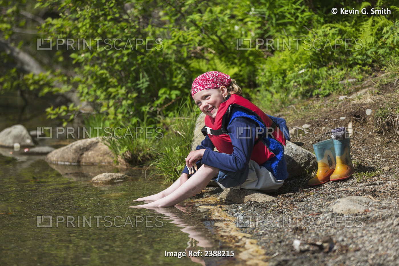 Young Girl Wearing A Lifejacket And Sitting On A Sun Drenched Shore Of Byers ...