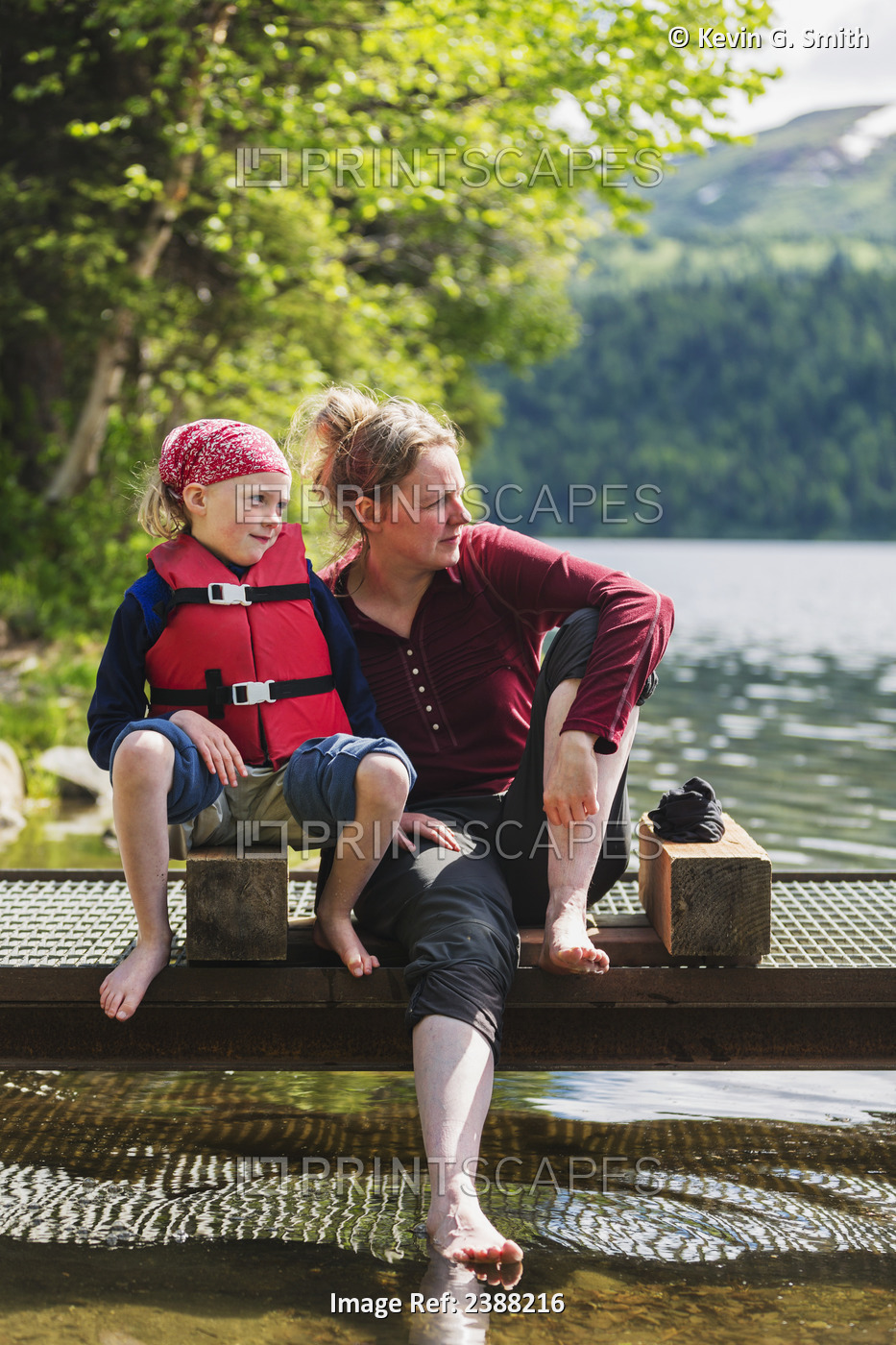 A Mother And Daughter Sits On A Dock Looking Out Over Byers Lake, Soaking Their ...
