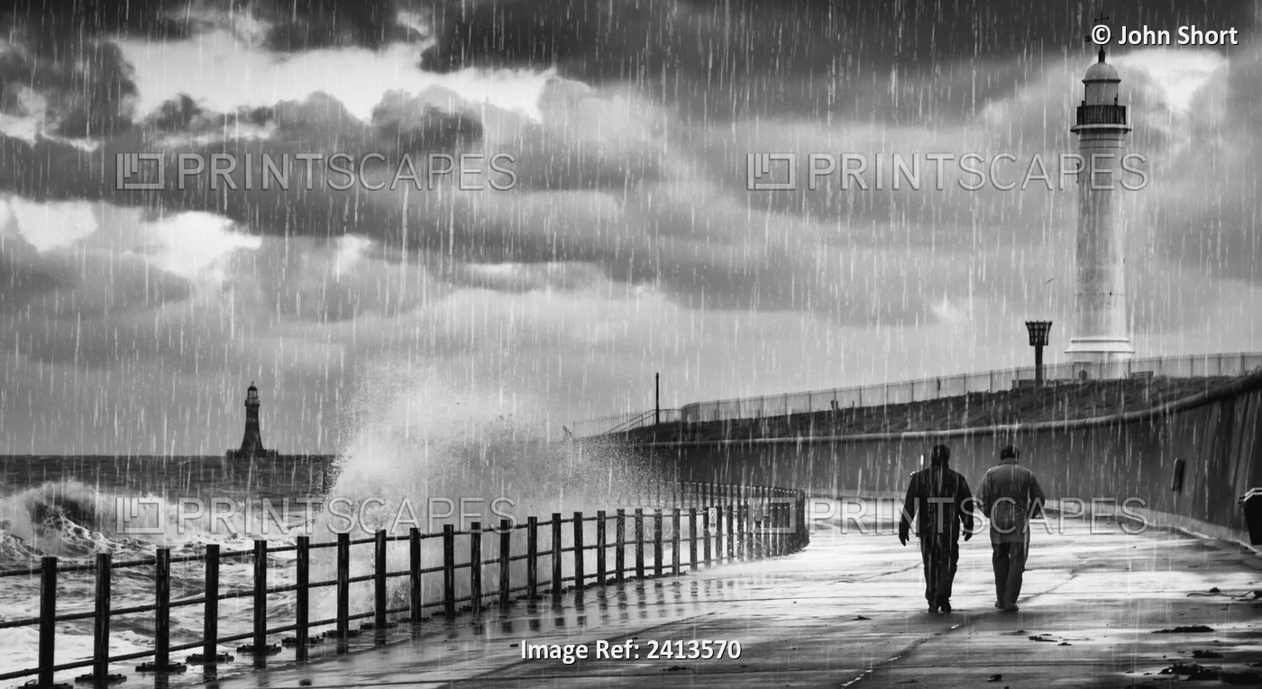 Two People Walking Along The Water's Edge In The Rain With Waves Crashing Into ...