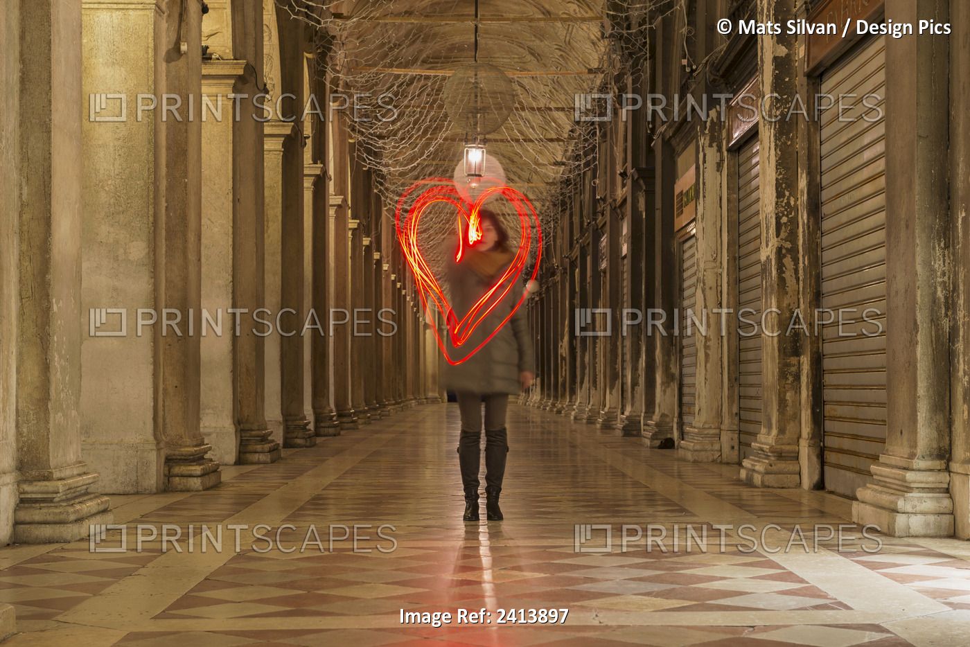 A Woman Walking In A Corridor Making A Red Heart Shape In The Air With Light ...