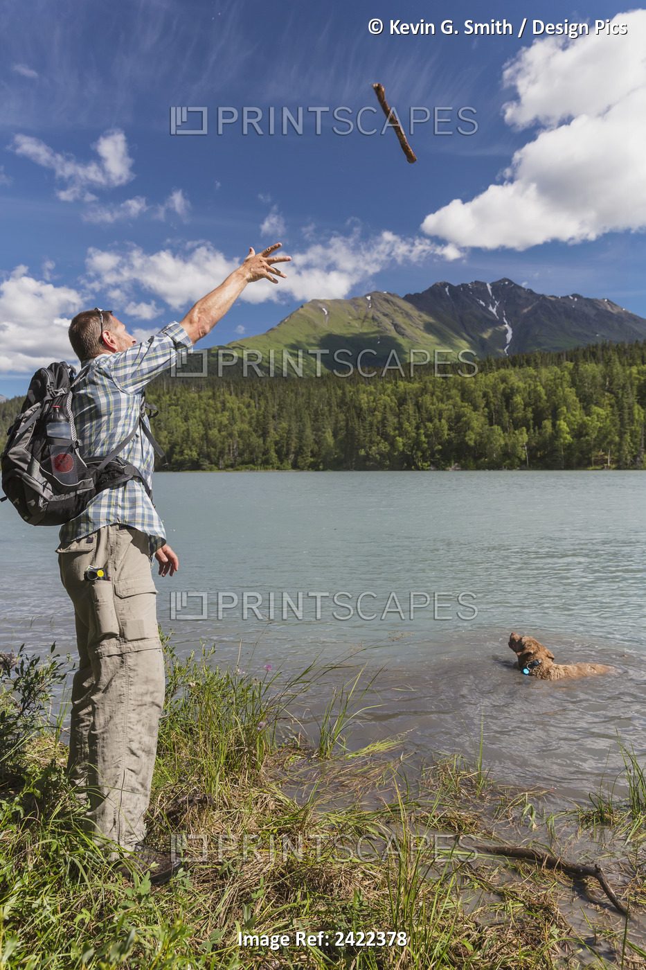 Male Hiker Playing Fetch With His Dog At Trail Lake With Kenai Mountains In The ...