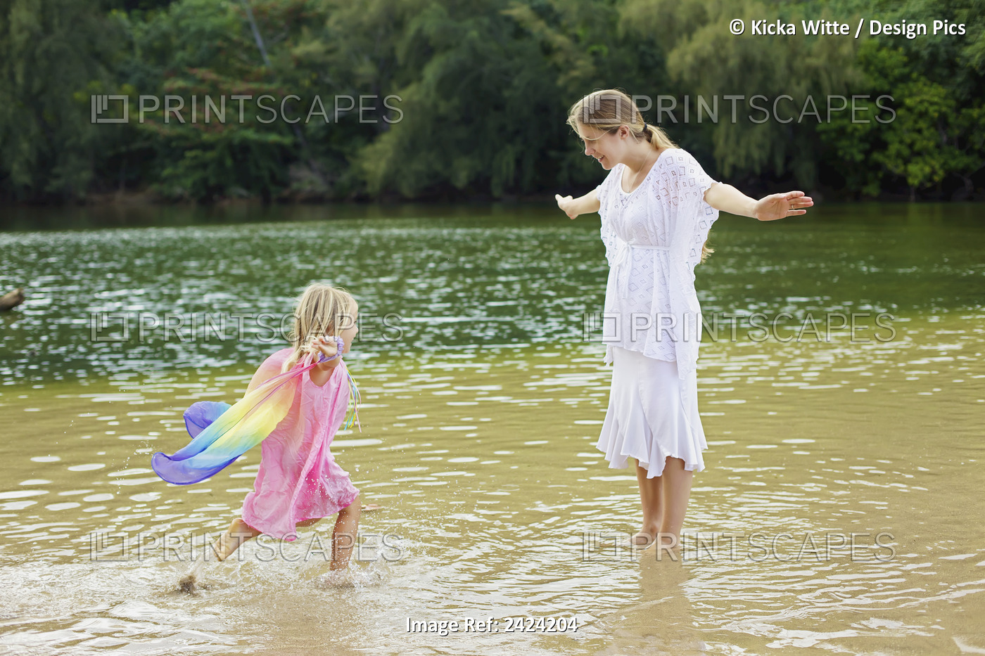 A Mother Plays In The Shallow Water Off The Beach With Her Young Daughter; ...