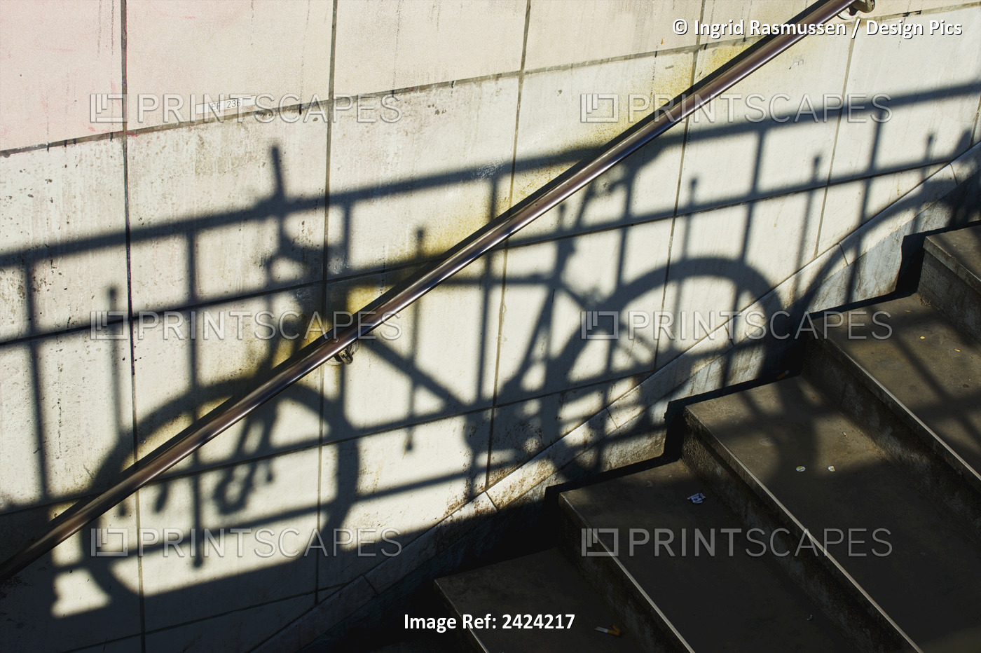 Shadow Of A Railing And Bicycle Cast On A Wall Along Steps; Paris, France