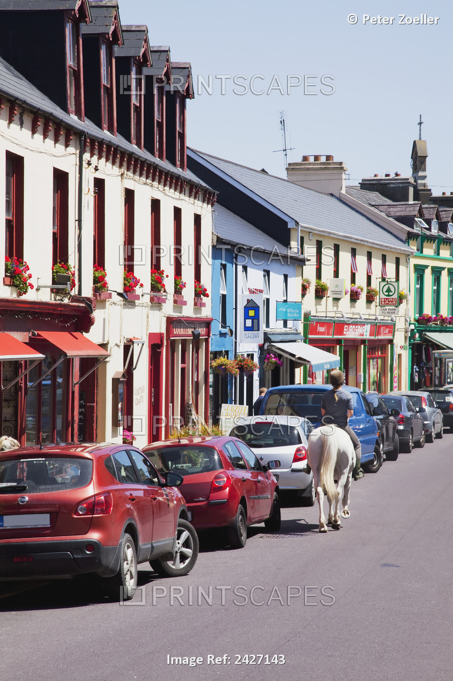 Riding A Horse Up The Street Beside Parked Cars And Retail Shops; Schull, ...