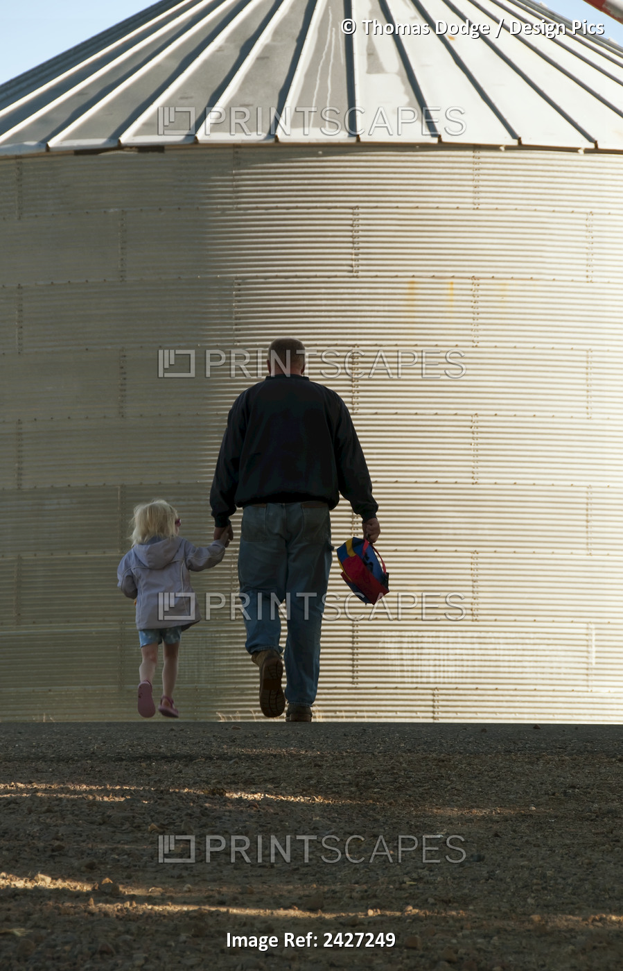Agriculture - A Farmer And His Young Daughter Walk Hand-In-Hand Through His ...