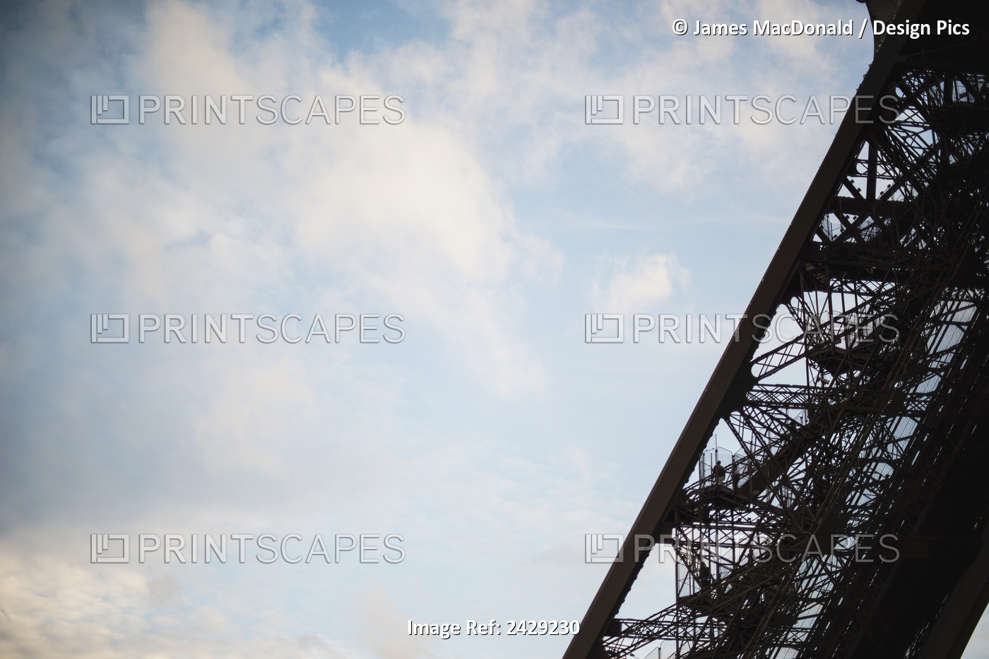 Visitors Climb One Of The Legs Of The Eiffel Tower In Paris As The Sun Sets ...