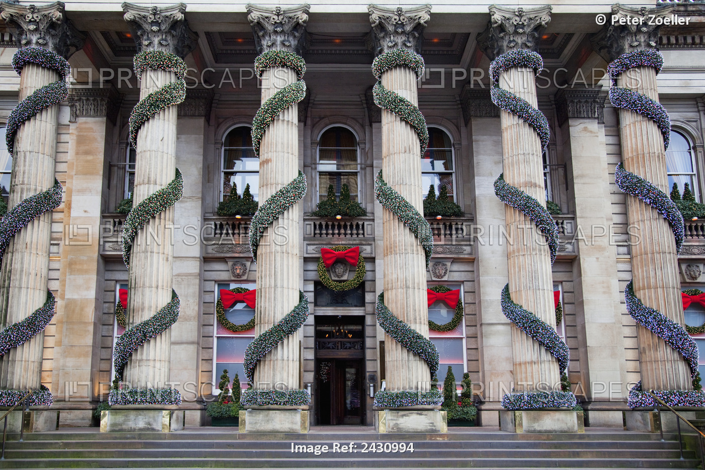 A Building With Columns Decorated With Garland And Wreaths At Christmas; ...