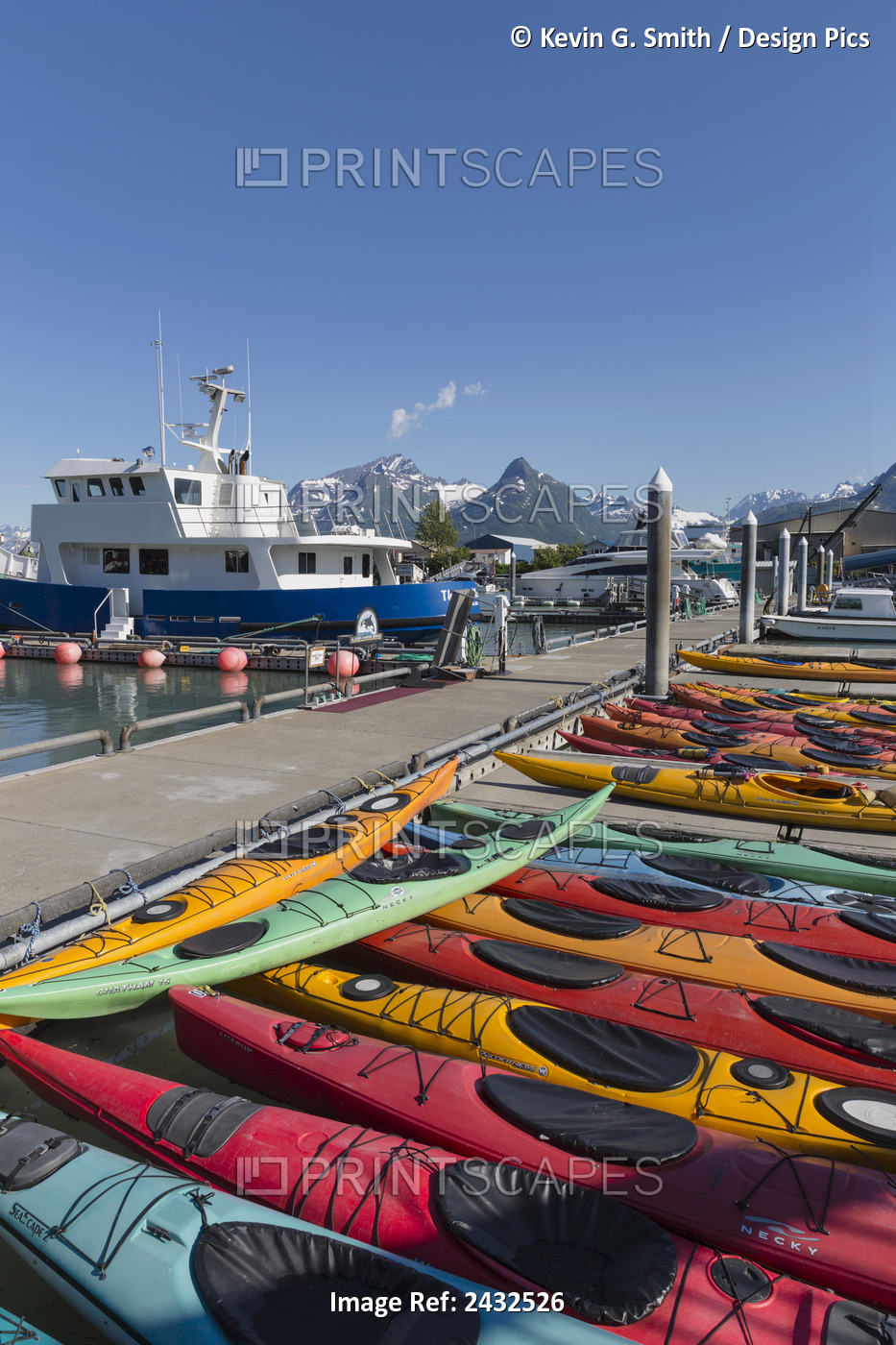 Multi Colored Kayaks At The Docks With Harbor And Mountains In Background, ...