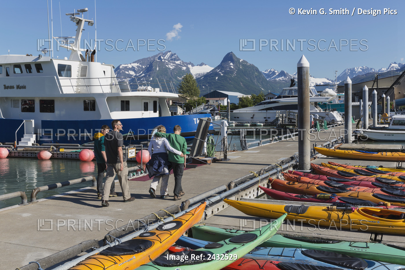 Family Walks On The Dock Past Multi Colored Kayaks With Harbor And Mountains In ...