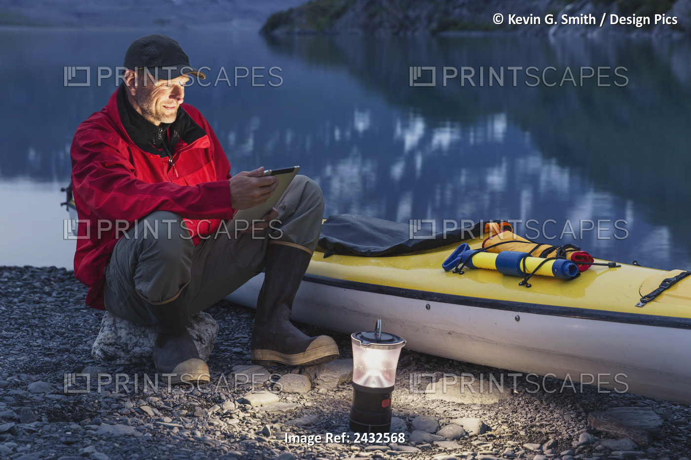 Man Reading On A Electronic Tablet While Camping With A Kayak At Shoup Bay ...