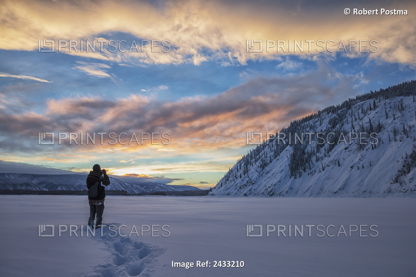 Photographer Shooting The Sunset Over The Yukon River; Dawson City, Yukon, ...