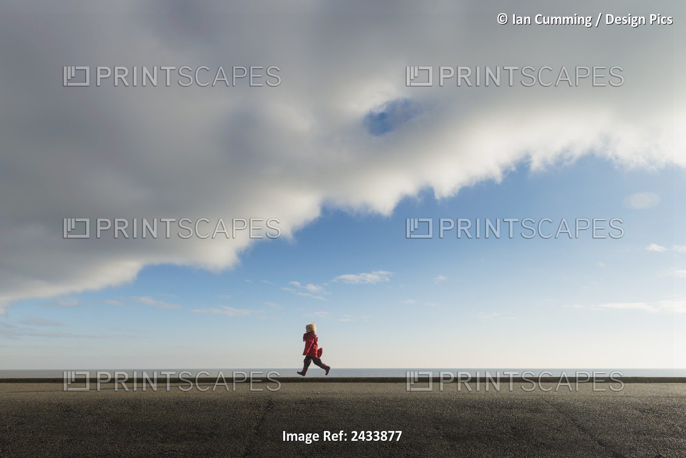Boy Running Along Sea Wall; Aldeburgh, Suffolk, England