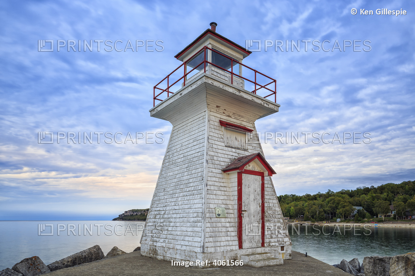 A worn and weathered lighthouse on the water's edge of Bruce Peninsula; ...