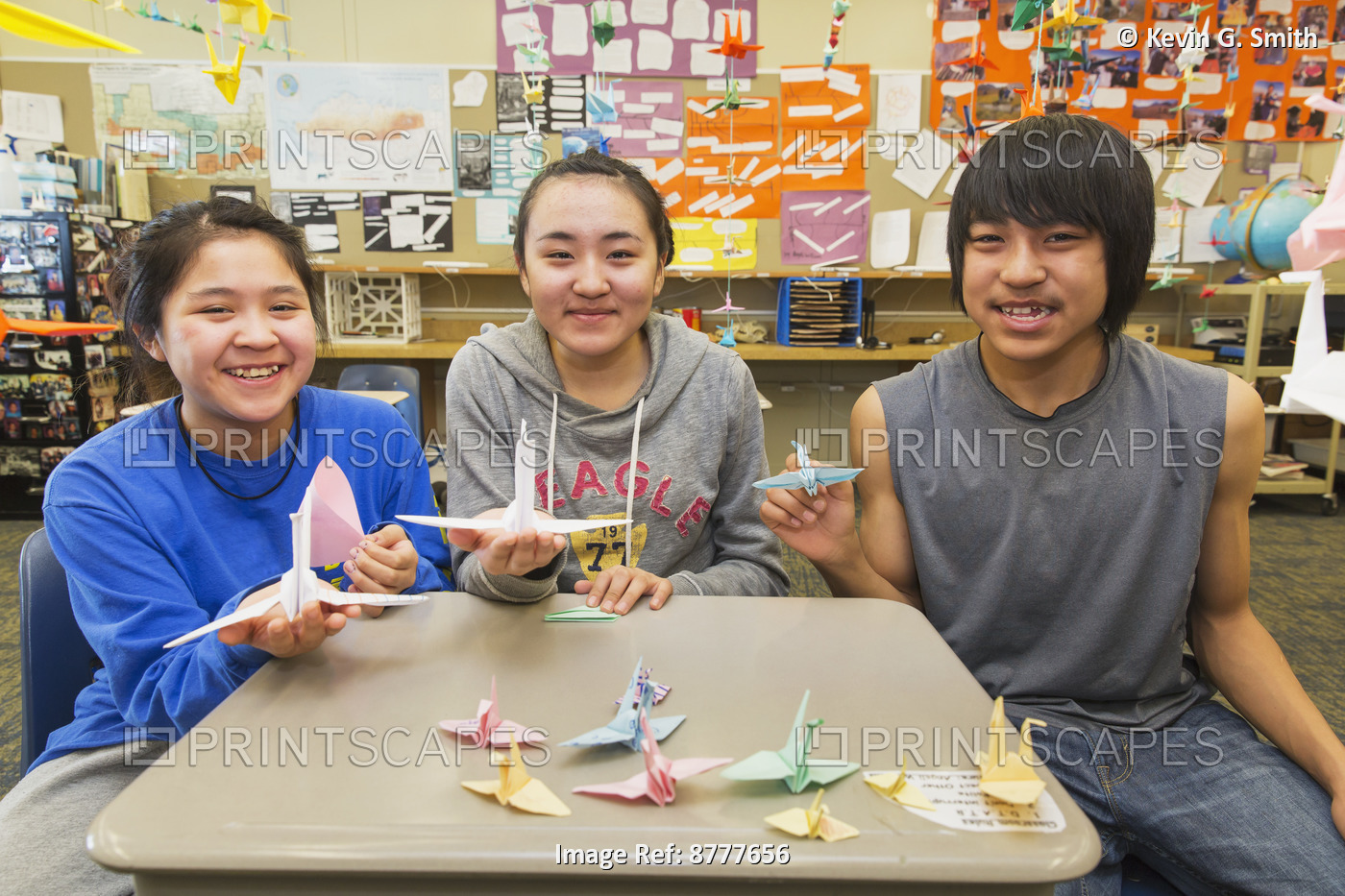Three High School Students Working On Origami Cranes For A Class Project, ...