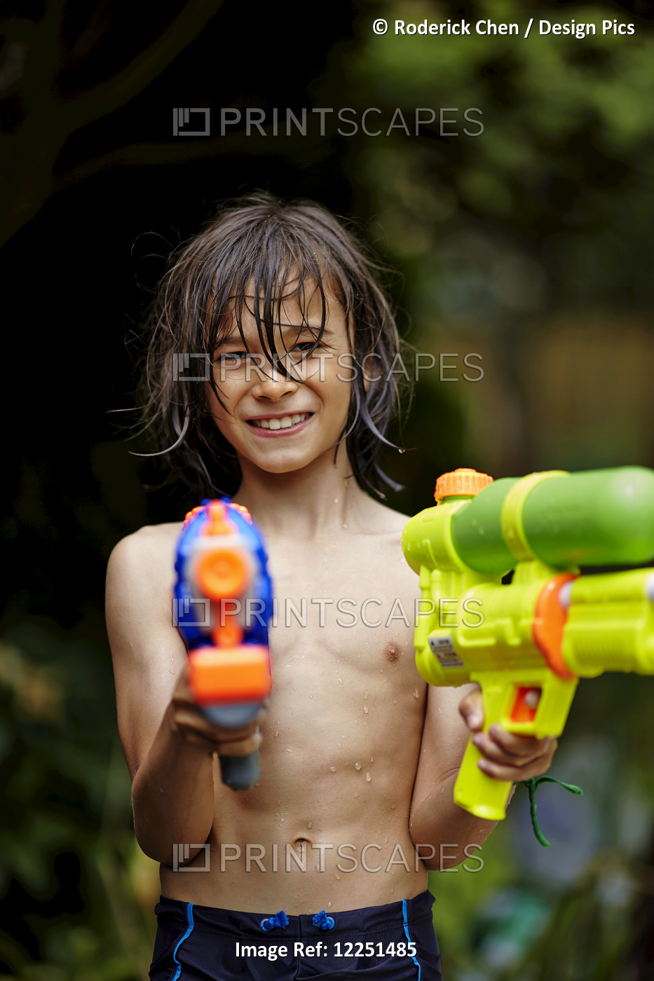 Young Boy Playing With Water Guns; Markham, Ontario, Canada