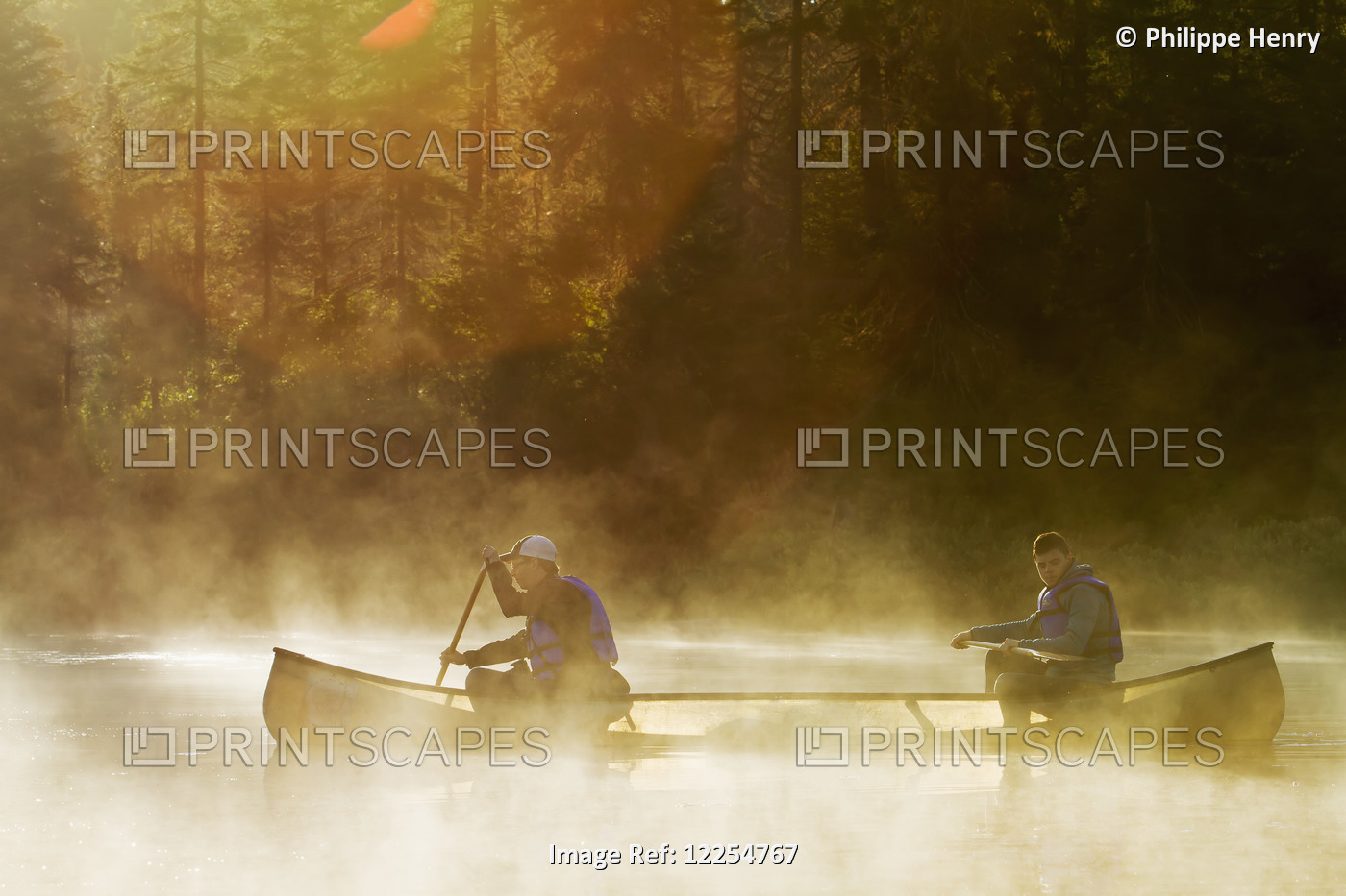 People Canoeing On A Lake At Dawn In La Mauricie National Park; Quebec, Canada