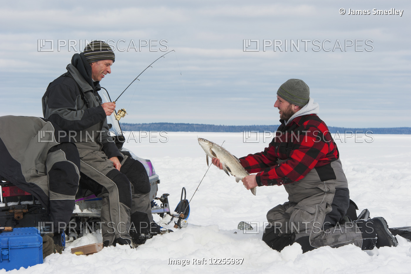 Two Ice Fishermen, One Holding A Large Whitefish; Ontario, Canada