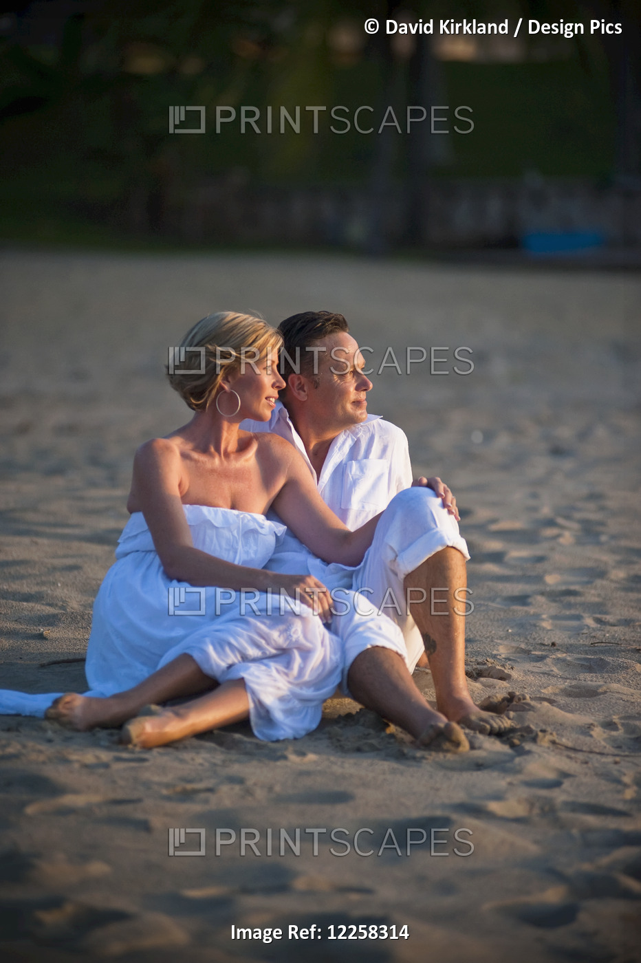 A Couple Sitting On The Beach At The Empire Hotel And Country Club; Bandar Seri ...