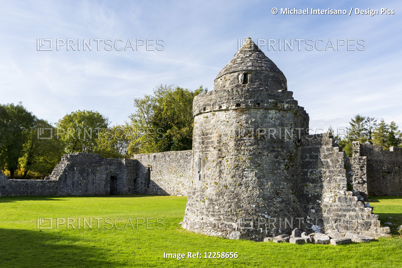 Ruins Of A Stone Castle With Stone Wall And Blue Sky; County Galway, Ireland