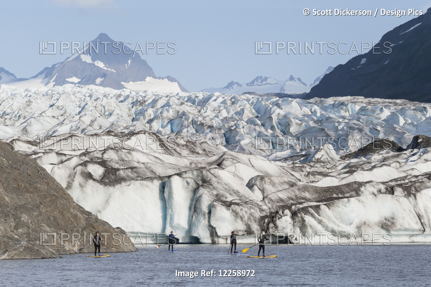 Standup Paddleboarders Paddling On Flatwater With The Grewingk Glacier In The ...