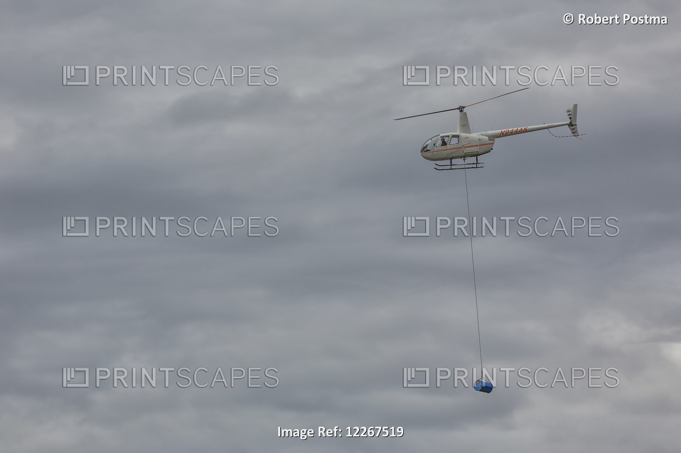 Helicopter Shuttling Fuel Barrels To A Roadless Community; Old Crow, Yukon, ...