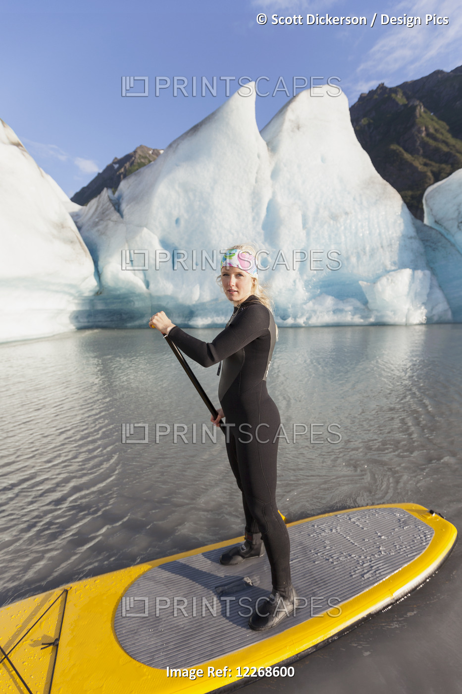 One Woman Stand Up Paddleboarding In Front Of Grewingk Glacier, Kachemak Bay ...