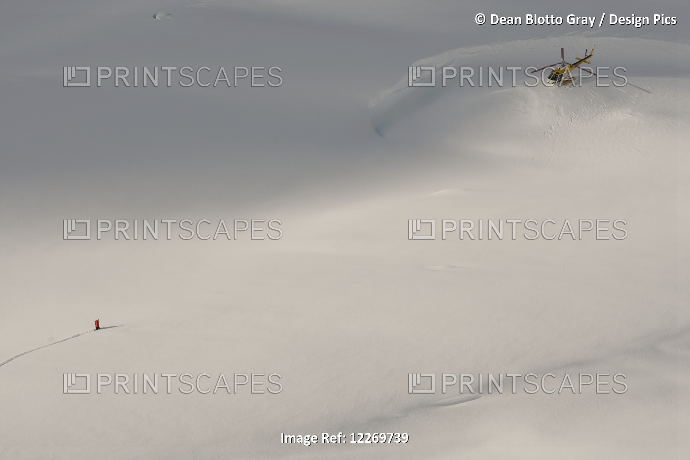 Aerial View Of A Snowboarder Walking Towards A Helicopter Perched On The Snow ...