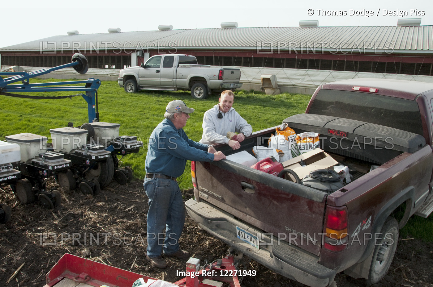 Father And Son Farmers Preparing For Spring Planting Of Grain Corn, Near ...