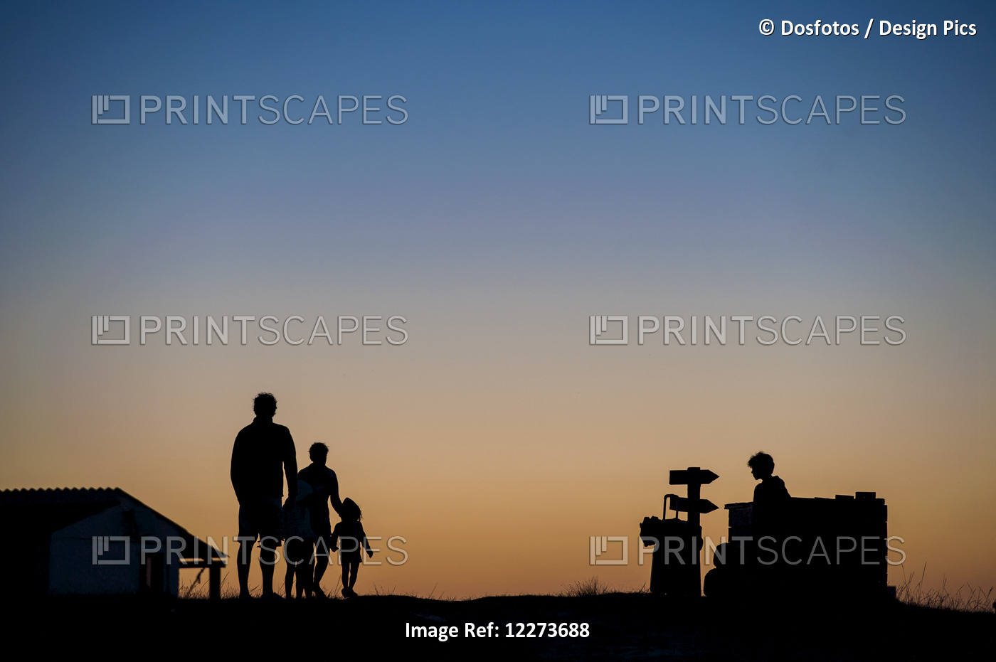 Silhouette Of A Family Standing And Watching The Sunset; Cabo Polonio, Uruguay
