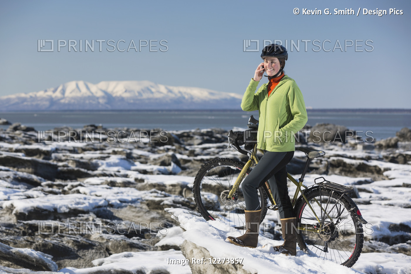 Young Woman With Her Bicycle Talks On A Cell Phone While Standing On Frozen Ice ...