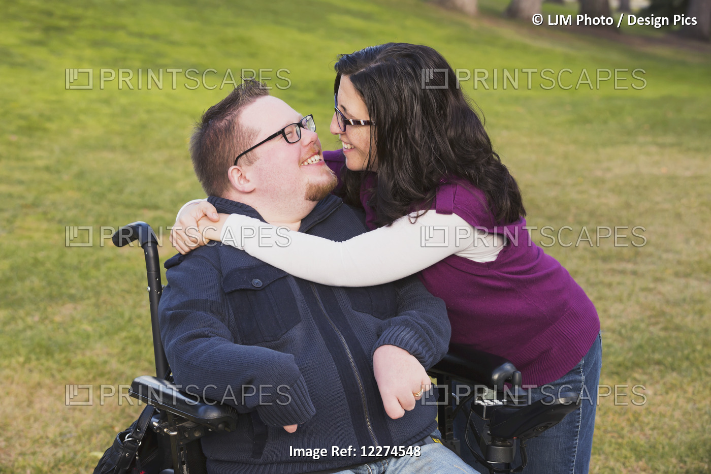 Wife Hugging Disabled Husband In A Park In Autumn; Edmonton, Alberta, Canada