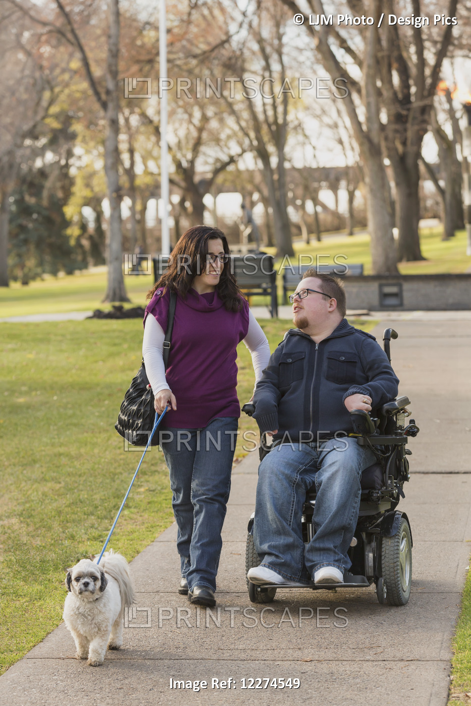 Disabled Husband Talking With His Wife While Walking In A Park In Autumn; ...