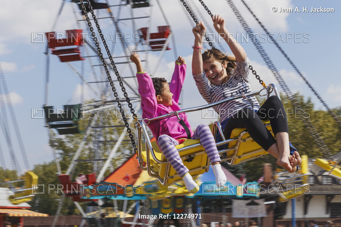 Sisters (Aged 5 And 12) Enjoying A Swing Ride; Edmonton, Alberta, Canada