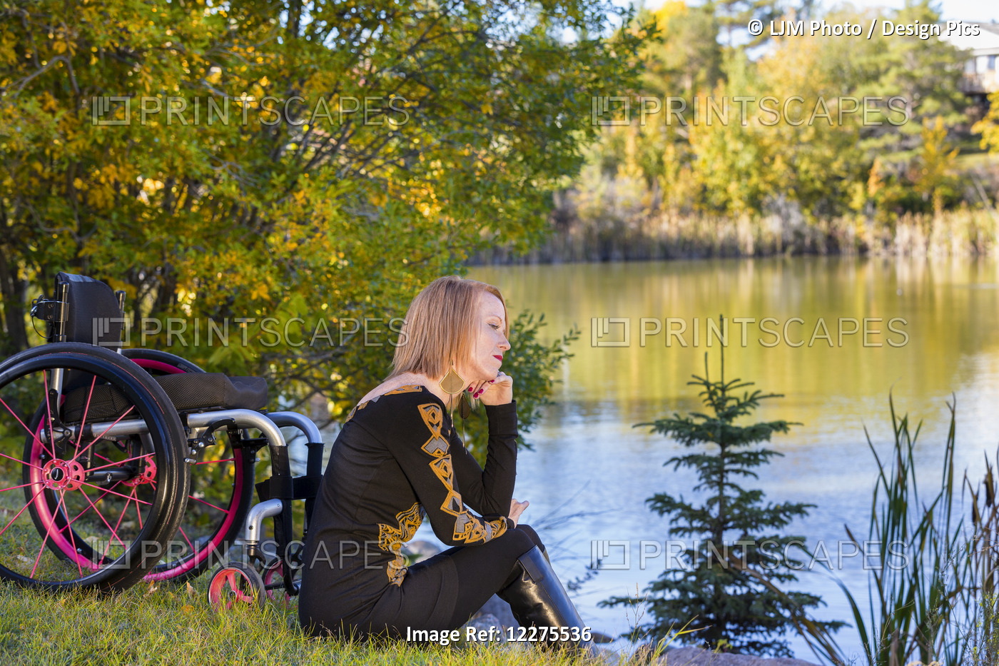 Young Disabled Woman Sitting Beside Her Wheelchair In A City Park In Autumn; ...
