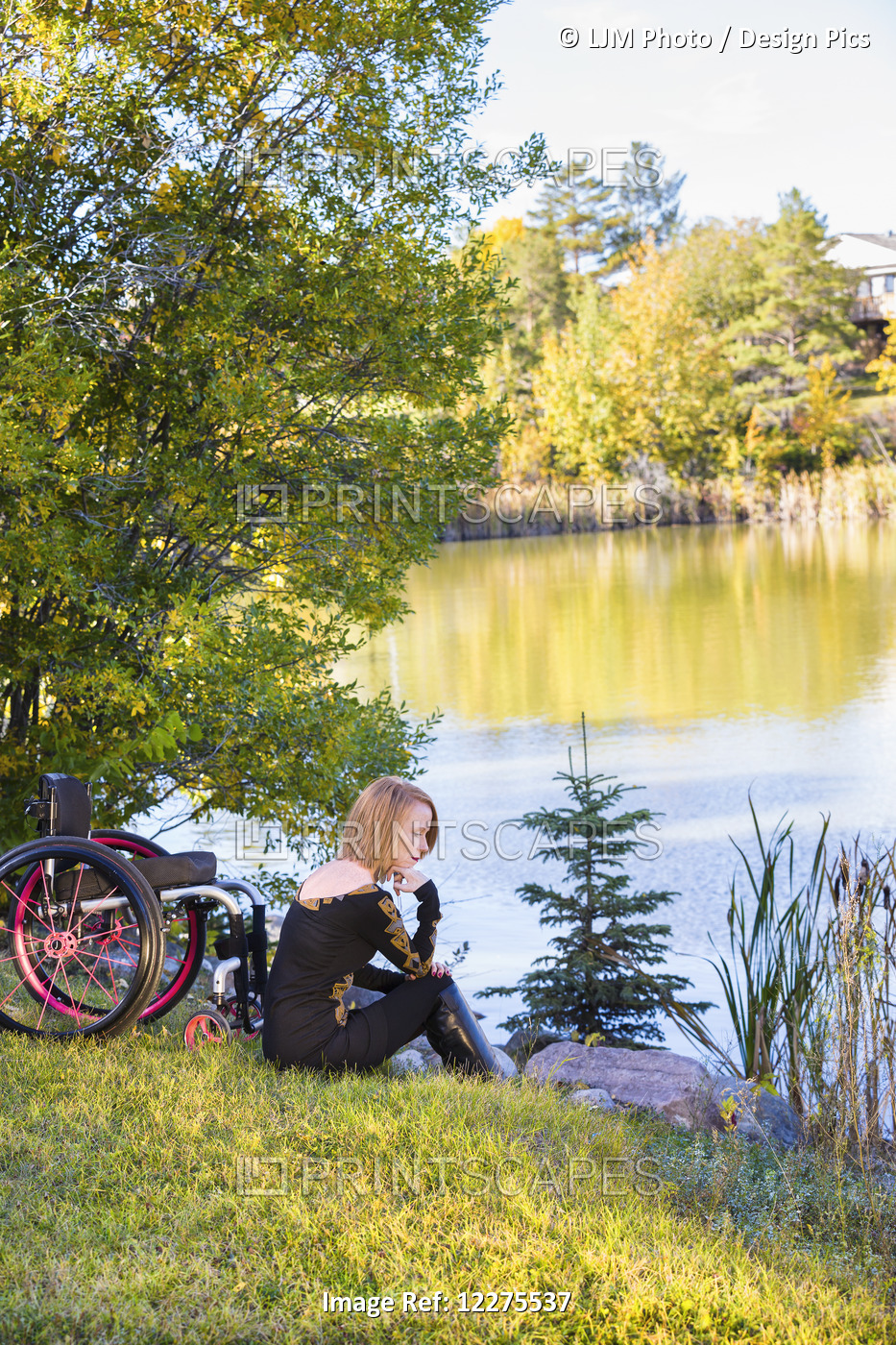 Young Disabled Woman Sitting Beside Her Wheelchair In A City Park In Autumn; ...