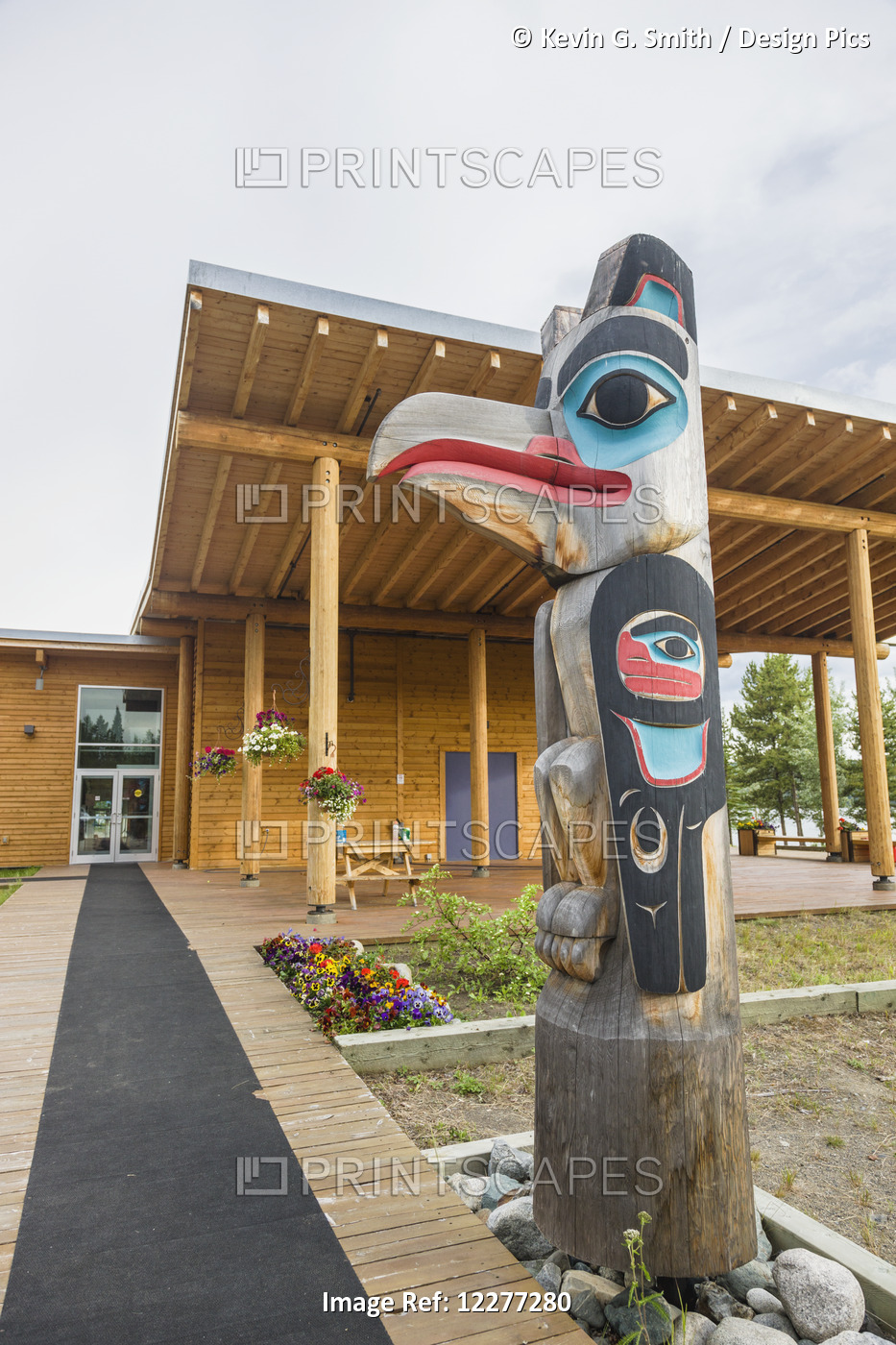 A Row Of Totem Poles Outside Of A Log Lodge, Whitehorse, Yukon Territory, Canada