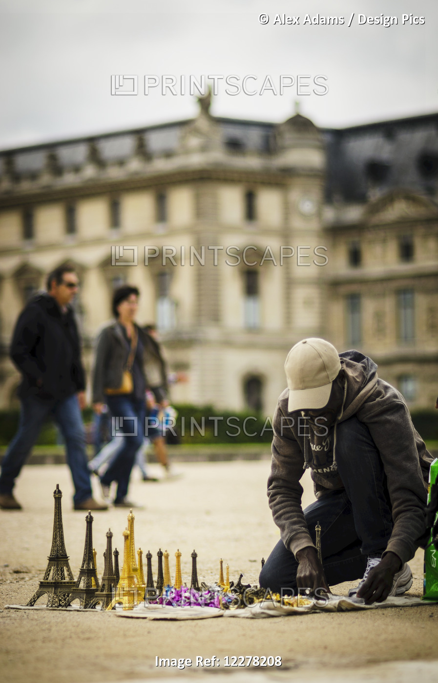 Man Prepares To Sell Eiffel Tower Miniatures To Tourists Outside The Louvre; ...